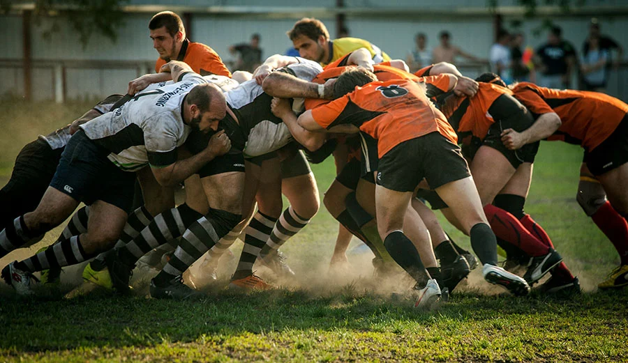 Rugby union forwards numbered 1 to 8 binding together in a scrum formation