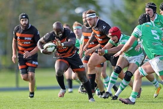 Rugby player carrying the ball at pace during a match